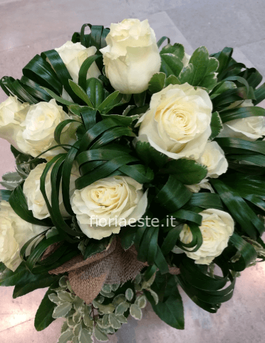 Bouquet di 12 rose bianche confezionato con fantasie di verdi